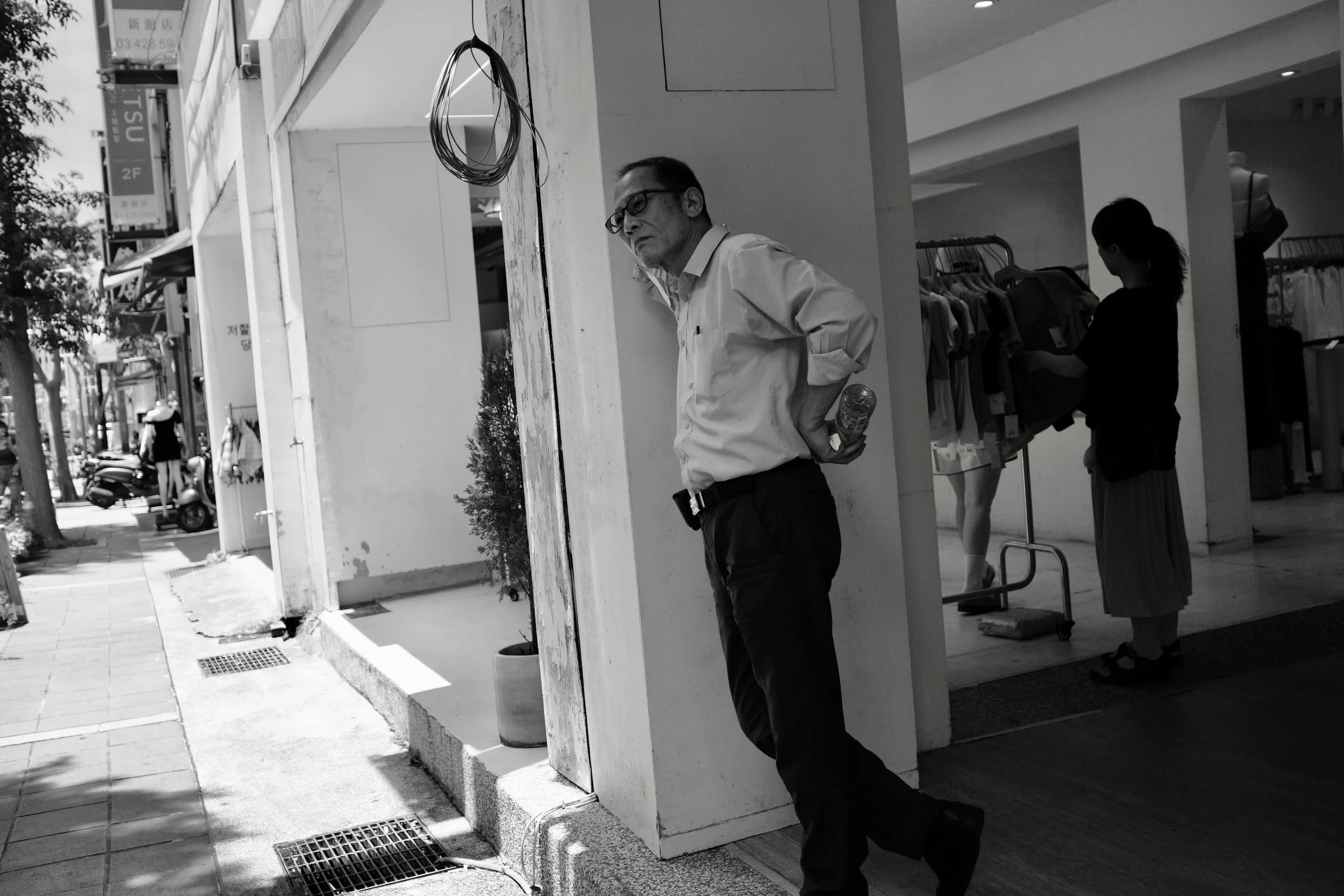 服飾店門口一名男子倚著柱子看向街道，365 Project September 9