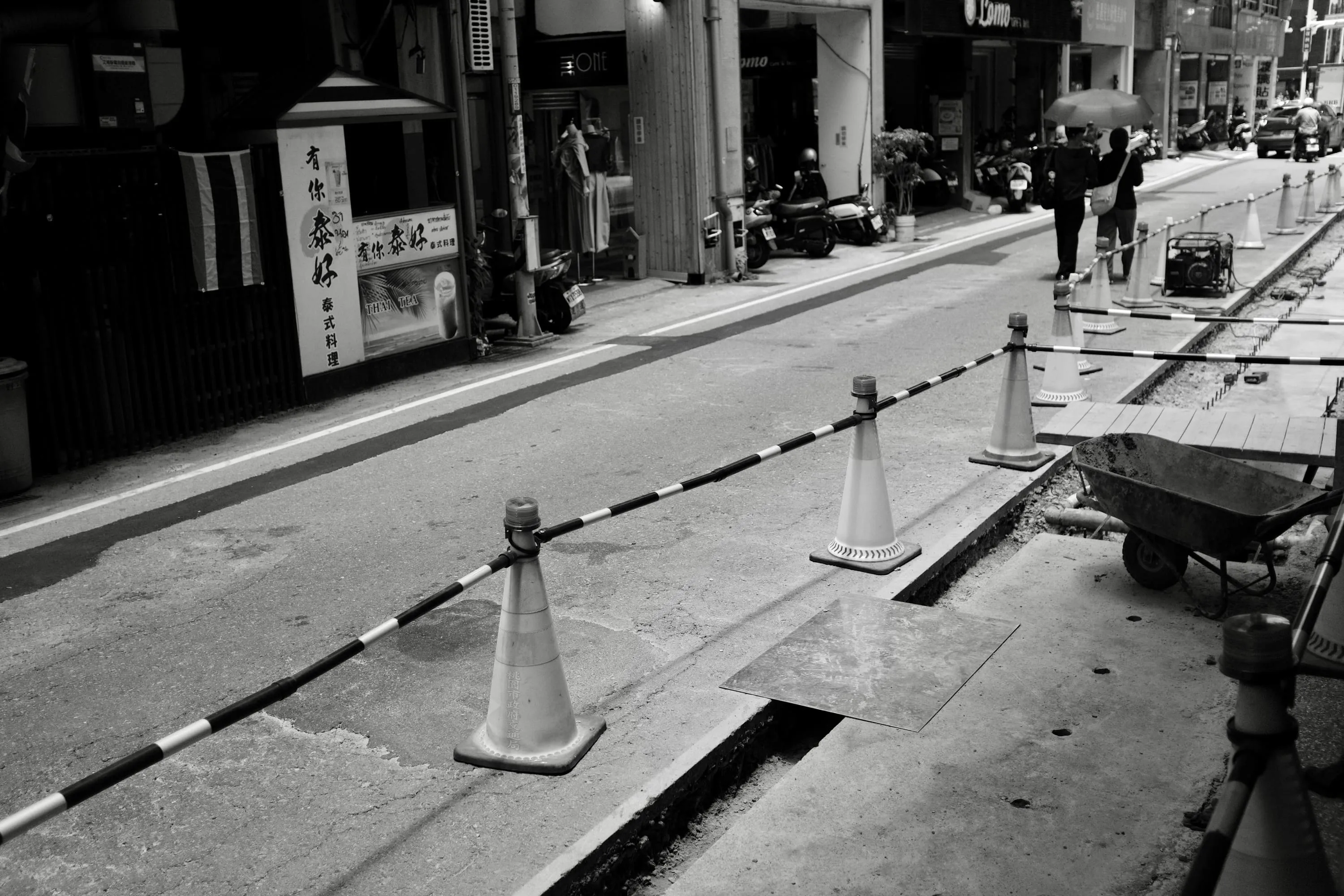 街道路面施工圍線旁遠處兩名行人撐傘走過，365 Project September 8