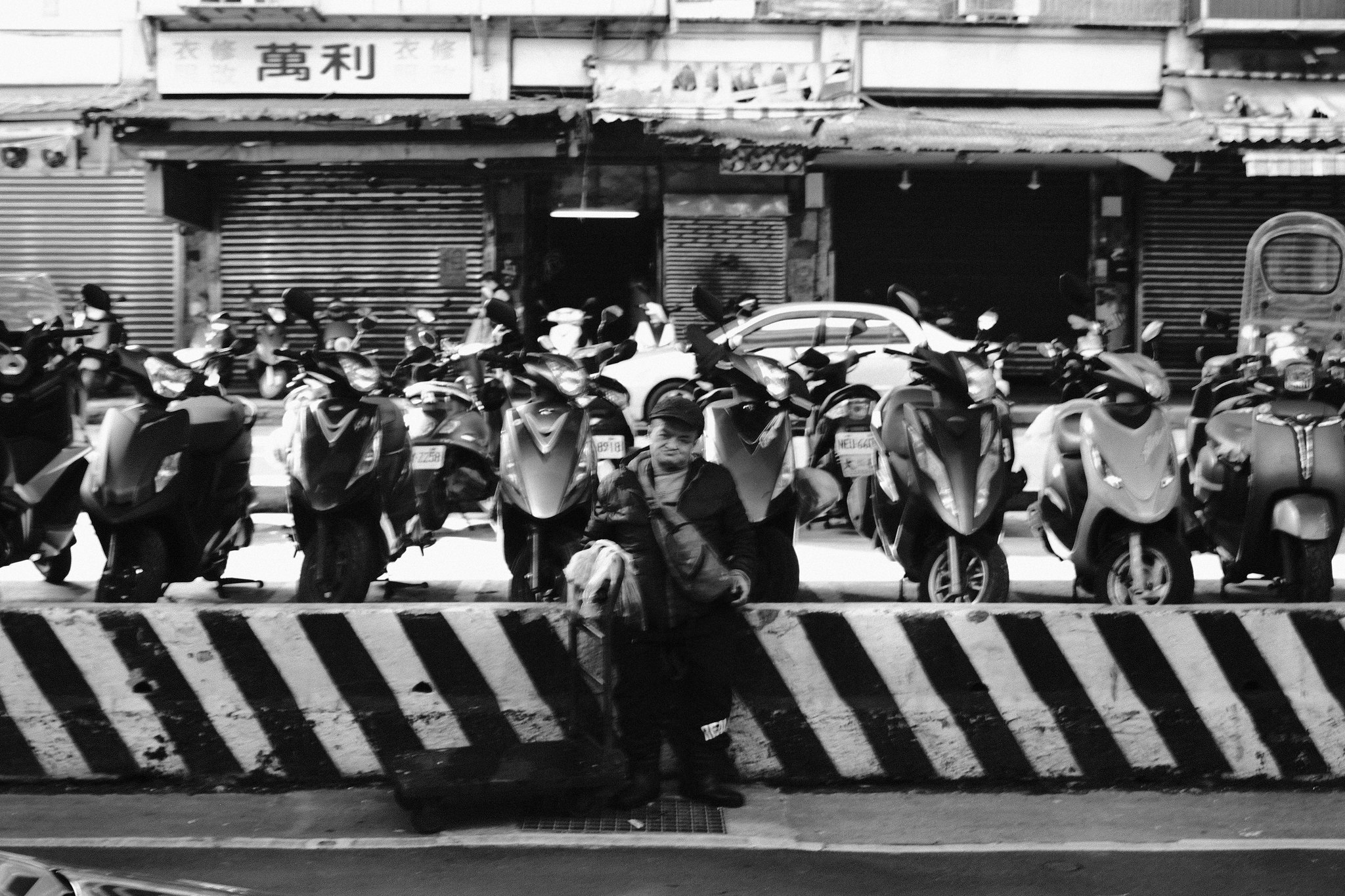 Bustling Keelung street with wet pavement and urban reflections